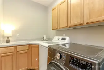 Nice sized utility room with cupboards and built-in sink.