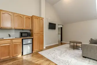 Bonus room off the upper landing leads into bedrooms 4 & 5. You can see built-in sink, microwave and mini-frig. Plenty of room for lounging and watching TV.