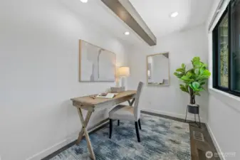 Create, focus, and inspire in this stylish home office featuring exposed wood beams, recessed lighting, and a serene window view.