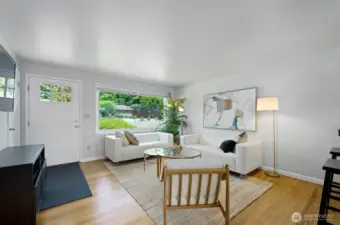Light filled living room with oak hardwood floors and a redesigned open concept.