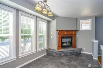 Gather in the dining area, where a gas fireplace with a rich wood mantel adds the perfect touch of elegance and comfort.