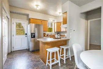 Kitchen with newer fridge, back door, and laundry closet to the left.