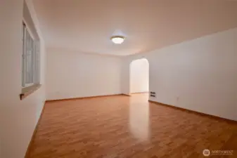 Living room space with arched way to dining area.
