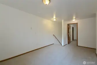large landing space at top of stairs can be used as office space or play area. new carpet 2025.