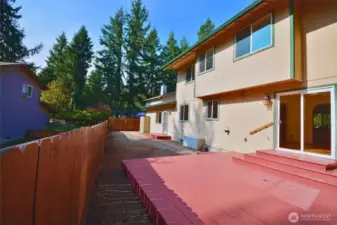 back exterior of home, pond view beyond fence.