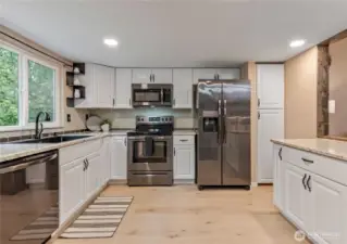 Upgraded kitchen with granite counters, upgraded appliances and new flooring