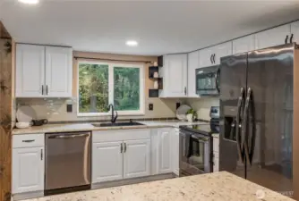 Upgraded kitchen with granite counters, upgraded appliances and new flooring