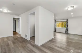 Looking back into the living area from the kitchen, view of the primary and laundry room