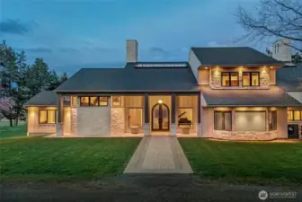 Elegant covered entry featuring custom iron and glass double doors, stone accents, and refined architectural detailing welcoming you into this luxury island residence.