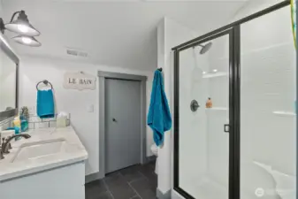 Upstairs bath has refer and coffee bar behind grey door.