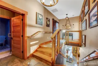 Entering the front door, you have the steam room to the left. The primary bedroom with living room office and wrap around porch ahead.  Downstairs to the kitchen and bar!