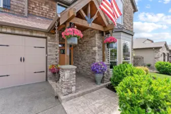 Welcoming entrance w/craftsman beams, iron strap detail and stone porch...