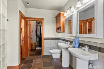 Dual pedestal sinks , separate water closet, bidet, tiled walls and dual medicine cabinets.