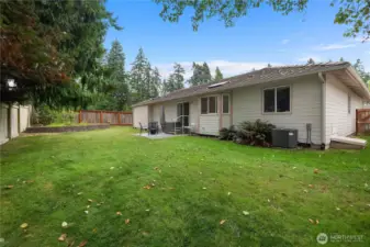 Fully fenced level backyard, with sprinkler system and patio.