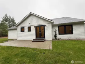 BACK OF HOUSE WITH LARGE CONCRETE PATIO FOR LOW MAINTENANCE