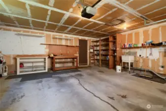 Large 2 car garage with work bench and some storage space.