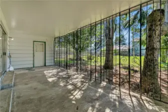 Large covered patio with privacy fencing accesses large level backyard