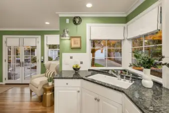 Heading into the kitchen from the dining room, notice all the windows, custom window coverings and French doors leasing to the backyard.