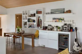 The dining area with built-in shelves and counter and beverage refrigerator.