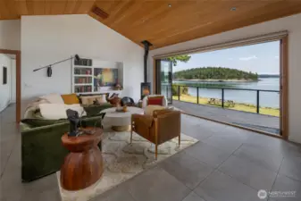 The living room features a wall of folding doors, opening up the room seemlessly to the outdoor living space. A free standing wood stove for to cozy up on winter days rounds out this great space.