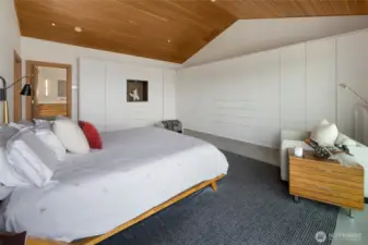 The primary bedroom features abundant built-in closet space, vaulted clear fir ceilings and recessed lighting.