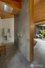 The walk-through shower with rain shower head and towel warmer. On the right a glimpse to the inner courtyard.