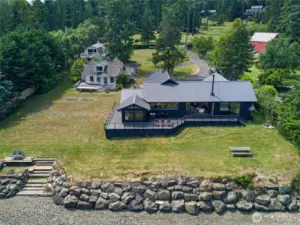 The main house in the front, the 1930 farm house on the left and the barn-style shop with apartment behind the farm house. Steps lead down the bulkhead onto the 150ft of private beach.