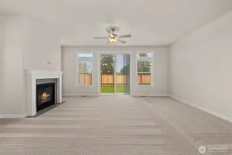 Living room with plenty of natural light featuring cozy gas fireplace with tile surround and ceiling fan.