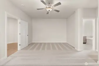 Inviting and spacious primary bedroom with ceiling fan for added comfort.