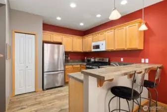 There is a pantry to the left of the refrigerator.