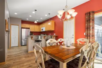 Looking across the dining room with the door leading to the garage and the glass sliding door that opens to the fully fenced rear yard and patio.