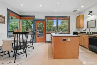 Love this kitchen! Wrapped in greenery and with great flow to the deck and backyard. Full bath to the right.