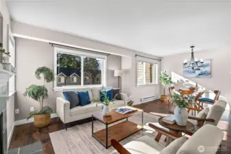 Abundant natural light streams into your open concept main floor living room and dining room. To the left is the stone-tile surrounded wood-burning fireplace and a picture window. Against the front wall, two large windows illuminate the living room and dining room.