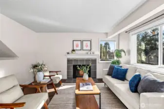 The living room welcomes folks to come in and cozy up. Strike up a warm wood fire in the winter, or open the windows to get a lovely cross-breeze. Above the mantle is a shallow niche  perfect for mounting a flat screen TV.