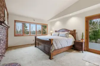 Primary bedroom suite has its own fireplace, French doors to the patio/hot tub area and decking, beautiful built-ins, ample storage, a walk-in closet and attached primary bath.