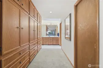 Extensive built-in cabinetry in the Primary suite with walk-in closet on the right. Bathroom straight ahead with commode, jetted tub and walk-in shower at the end of the hall on the right.