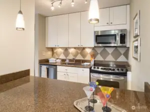 Backsplash details, pendant lights and classy finishes make this kitchen really shine.