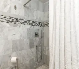 ADU bath with marble tile walls and shower