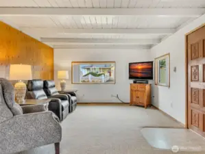 The entryway featuring propane stove, classic wood paneling and large picture window facing the neighborhood.