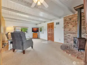 The entryway featuring propane stove, classic wood paneling and large picture window facing the neighborhood.