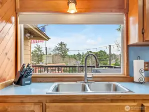 Large window over the sink overlooking the back porch.