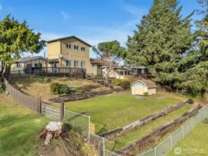Tiered backyard with green house. Plenty of space for gardening. This yard is also fully fenced.