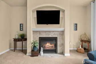 Elegant gas fireplace with art/TV alcove above and symmetrical spaces ideal for built-in bookcases creates a beautiful focal point in the inviting living room.