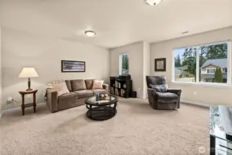 Opposite view shows the generously sized room with plush carpet and large windows bringing in beautiful natural light.