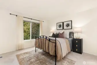 Upper level primary bedroom with views of serene greenery!