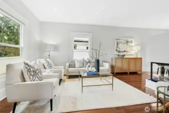 The living room with high ceilings and hardwood floors.