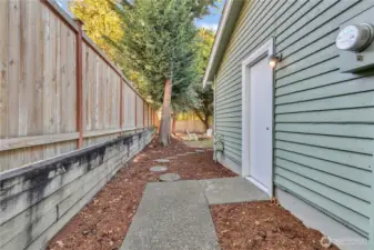 Level side yard, door is to the garage, behind is the gate to the front yard