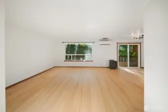 The large living room with brand new flooring, has access to the rear yard, newer ductless heat pump (AC!) and a cozy gas fireplace