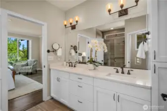 Primary bath is pristine and timeless with light Quartz counters, oil rubbed bronze fixtures, classic white cabinetry & tile flooring.