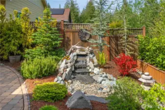 Custom water fall feature creates a soothing ambiance while enjoy the beautiful vistas from the backyard.  Also on a timer.